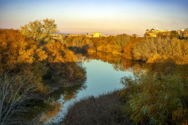 Guadalquivir nehri üzerinde, Crdoba, Endülüs, İspanya 'dan geçerken sıcak akşam ışıklarıyla manzara