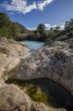 Fuente Caputa, Mula, Murcia Bölgesi 'nin kaynağının dikey fotoğrafı, kayalar ve güneşli bir günde,