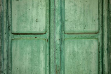 Antik çift yapraklı pencere. Zamanla eskimiş. Açık yeşille boyanmış.