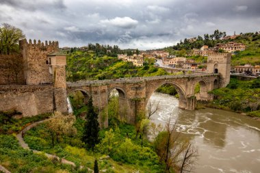 Toledo, Castila la la Mancha, İspanya 'daki ortaçağ San Martin köprüsünün Tagus nehri üzerindeki görüntüsü