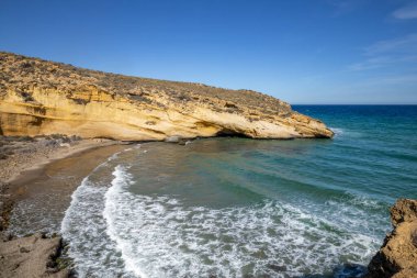 Cabo Cope ve Puntas de Calnegre Bölgesel Parkı 'nda kristal berrak suları ve sarı kayalıkları olan güzel bir koy.