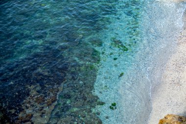 View from above of the shore of a beach with crystal clear emerald green waters in the Puntas de Calnegre regional park in the Region of Murcia, Spain clipart