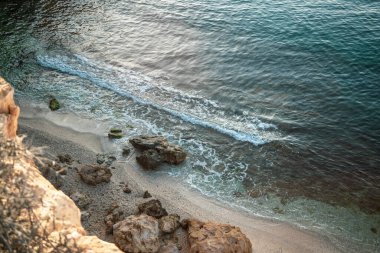 View from above of Cala Blanca of the Puntas de Calnegre regional park in the Region of Murcia, Spain with gentle waves and rocks on the shore clipart