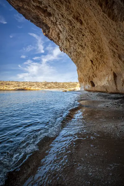 stock image Vertical photo of Cala Blanca beach under a cave in the Puntas de Calnegre regional park in Lorca, Region of Murcia, Spain