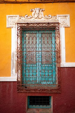 Vertical photo of a lovely old ornate and colorful window of the old town of Chinchilla de Montearagon in Albacete, Castilla la Mancha, Spain clipart