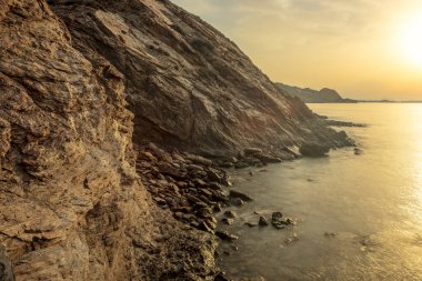 İspanya 'nın Murcia bölgesinin Aguilas kentindeki Playa Amarilla' da gün doğumunda sıcak ve durgun sularıyla sersemletici kayalık kayalıklar.