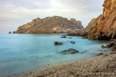İspanya 'nın Murcia bölgesindeki Amarilla sahilindeki küçük ve huzurlu körfez, şeffaf suları ve arka planda Kırılgan Adası ile birlikte uzun süre korunmasız bırakıldı.