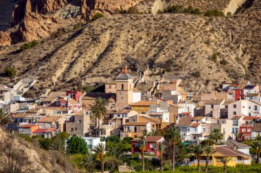 İspanya 'nın Murcia bölgesindeki Ricote Vadisi' ndeki Ulea kasabası, başrol oyuncusu olarak kilise kulesi ve arkasındaki kurak dağ.