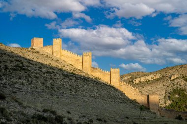 Ortaçağ Albarracn, Teruel, Aragon, İspanya 'nın savunma duvarlarını altın gece ışığıyla kaplayan manzaralar.