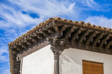 İspanya 'nın Guadalajara, Atienza kentindeki bir evin cephesinde heykellerle dolu bir sütun ve birçok detayla oyulmuş ahşap bir korsenin mimari ayrıntıları.