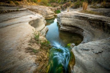 Moratalla 'da Bolvonegro Boğazı' nın doğal alanı, Murcia Bölgesi, yumuşak akşam ışığı ve ön planda Alhrabe nehri ile