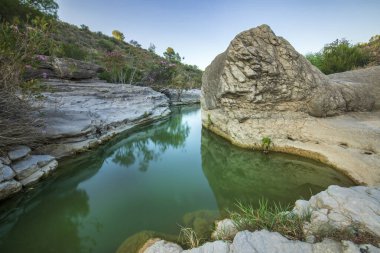 Moratalla 'da Bolvonegro Boğazı' nın doğal alanı, Murcia Bölgesi, yumuşak akşam ışığı ve ön planda Alhrabe nehri ile