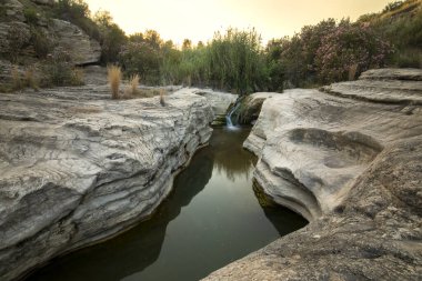 Moratalla 'da Bolvonegro Boğazı' nın doğal alanı, Murcia Bölgesi, yumuşak akşam ışığı ve ön planda Alhrabe nehri ile