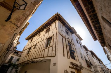 Tipik beyaz ev, Requena, Valencia, İspanya 'nın tarihi merkezinde, bir caddenin köşesinde, güneşin arkadan aydınlattığı ortaçağ ahşap kirişleri ile.