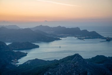 İspanya 'nın Murcia Bölgesi, Cartagena sahilinin gündoğumu manzarası sakin bir yaz günü, arka planda liman