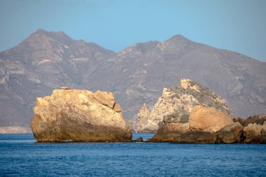 İspanya 'nın Murcia bölgesindeki Cartagena kıyısındaki kayalıkların manzarası sabahın erken saatlerinde ve denizde küçük kayalar ve adalarla