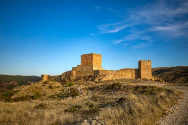 Ortaçağ Albarracn, Teruel, Aragon, İspanya 'nın savunma duvarlarını altın gece ışığıyla kaplayan manzaralar.