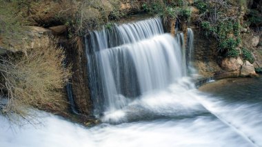 Water falls with long exposure in the Cerrada del Ro Castril in the town of the same name, in Granada, Andalusia, Spain clipart