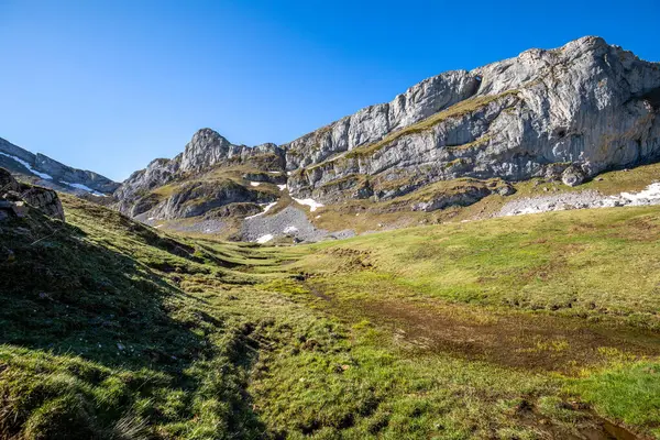 Panoramic view of the mountains of the Somiedo Natural Park in Asturias, Spain, with a spectacular view from the top in the middle of spring, snow on the peaks and grass in the valleys