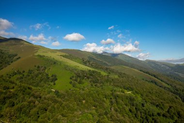 Typical mountainous landscape of the Saja-Besaya natural park in Cantabria, Spain, with rolling mountains covered with vegetation clipart