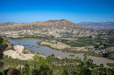 Panoramic view of the Ojs reservoir, in the Ricote Valley, Region of Murcia, Spain, with the town of Blanca in the background clipart