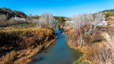 Cabriel nehri kışın Cuenca, Castilla-La Mancha, İspanya 'dan güzel gün ışığıyla geçerken görüntülenir.