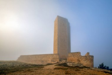 İspanya 'nın sisli bir gününde, Cuenca, Castilla-La Mancha, Alarcon kasabasındaki Ortaçağ Torre de Armas manzarası
