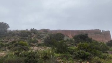 Bulutlu bir günde İspanya 'nın Murcia kentindeki El Valle y Carrascoy Doğal Parkı' ndaki La Asomada Ortaçağ Şatosu 'nun kalıntılarının hava görüntüsü..