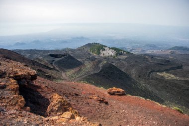 İtalya 'nın Sicilya kentindeki Etna Dağı' nın krater ve yamaçlarının muhteşem ve renkli manzarası, arka planda Catania kenti var.