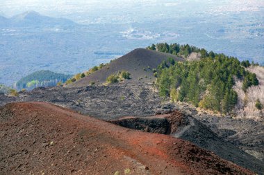 İtalya 'nın Sicilya kentindeki Etna Dağı' nın krater ve yamaçlarının muhteşem ve renkli manzarası, arka planda Catania kenti var.