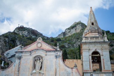 İtalya, Sicilya 'da Taormina' daki Piazza IX Aprile 'deki Chiesa de San Giuseppe cephesinde dağlar arkasında.