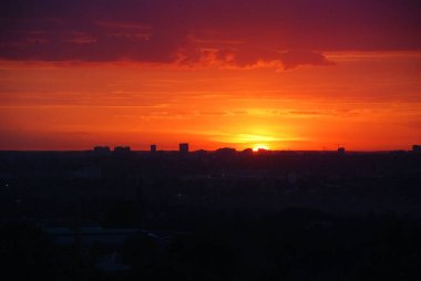 Horizon at sunset. Abstract city landscape background. Red sky with clouds over the city, beautiful panoramic view.