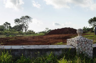 A piece of land within a wall is cleared for house construction.