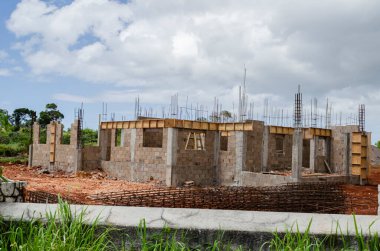 Kemerle kapatılmış duvarın tepesine kirişi atmak için kısmen kutulanmış bir ev inşa ediliyor..