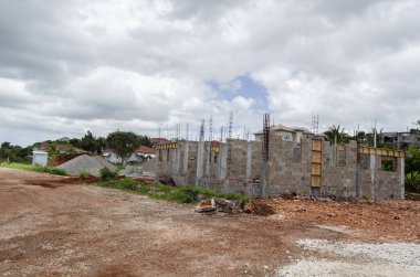 Yol kenarındaki bir ev kemer parkuruna inşa ediliyor. Kirişi tıkanmış duvarın tepesine atmak için kısmen kutulanmış..