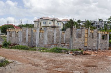 Kemerle kapatılmış duvarın tepesine kirişi atmak için kısmen kutulanmış bir ev inşa ediliyor..