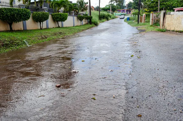 stock image A stream of water runs down the roadway after a shower of rain.