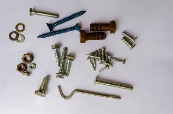 stock image Nuts bolts, screws, washer and a drape hook are on a white background.