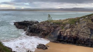Donegal İrlanda 'da kayalık bir kıyıya vuran dalgaların videosu..