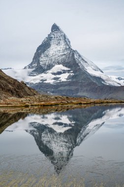 Apls scenery with the Matterhorn Mountain and its reflection in a lake. clipart