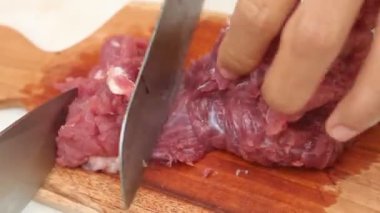 Keskin bir bıçakla tahta kesme tahtasındaki eti dilimlemek. koyun eti ve sığır eti temaları için uygun.