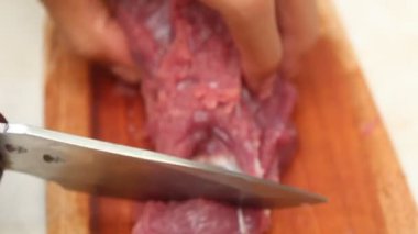 Keskin bir bıçakla tahta kesme tahtasındaki eti dilimlemek. koyun eti ve sığır eti temaları için uygun.