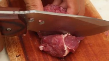 Keskin bir bıçakla tahta kesme tahtasındaki eti dilimlemek. koyun eti ve sığır eti temaları için uygun.