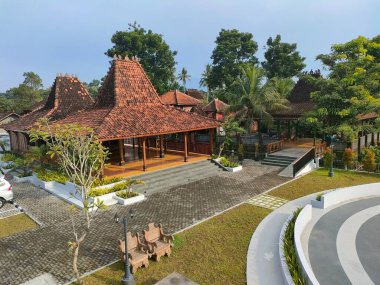 Geleneksel Javalı (Joglo) tarzı bina, kendine özgü bir terracotta çatısı ve yeşil peyzaj ile çevrili ahşap sütunları vardır. Seyahat, kültür ve mimari için mükemmel.