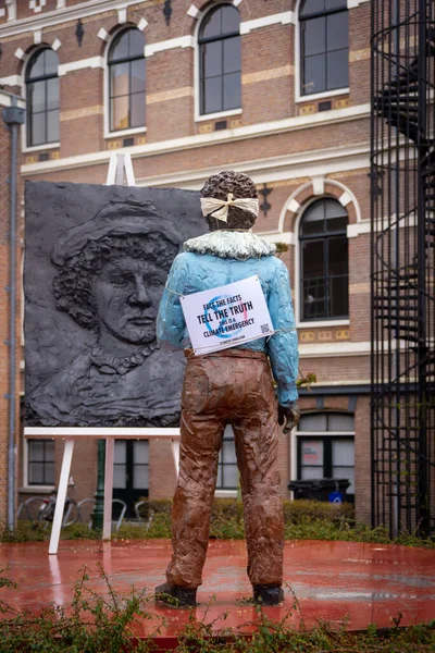 26 Mart 2023, Leiden, Hollanda, iklim aktivistleri Rembrants heykelinin yanı sıra ülkenin dört bir yanındaki heykellerin gözlerini bağlayarak,