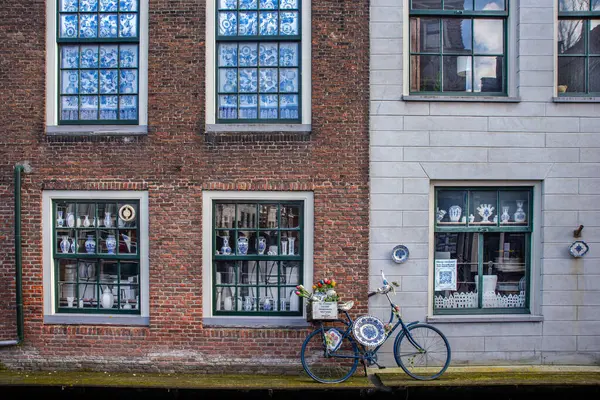 27.03.2023 Delft, Hollanda, Kanal üzerinde mavi çömlek mağazası mavi çömleklerle süslenmiş bisikletlerle 