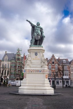 31.03.2025, Gent, Belçika, Jacob van Artevelde 'nin heykeli Vrijdagmarkt meydanında, tarihi binalar ve yapılarla çevrili, bulutlu bir gökyüzünün altında yüksekte duruyor..