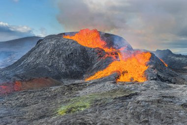 Reykjanes Yarımadası 'nın İzlanda manzarası. Parlayan lavları olan aktif bir volkanın görüntüsü. Volkanik krater gün boyunca gün ışığıyla patlayacak. Kraterin etrafındaki soğutulmuş magma kayaları