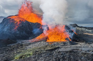 Volkan parlayan sıcak lav püskürtür. İzlanda Reykjanes Yarımadası 'ndaki aktif bir volkandan gelen lav çeşmesi. Gündüzleri Geopark 'ta manzara. Volkanik kraterin üzerinde buhar oluşumu