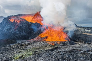 İzlanda 'da aktif volkan. Reykjanes Yarımadası 'ndaki volkanik kraterden gelen fıskiyeyle parlayan sıcak lav. Geopark 'ta gün ışığında manzara. Volkanik kraterin üzerinde güçlü bir buhar oluşumu